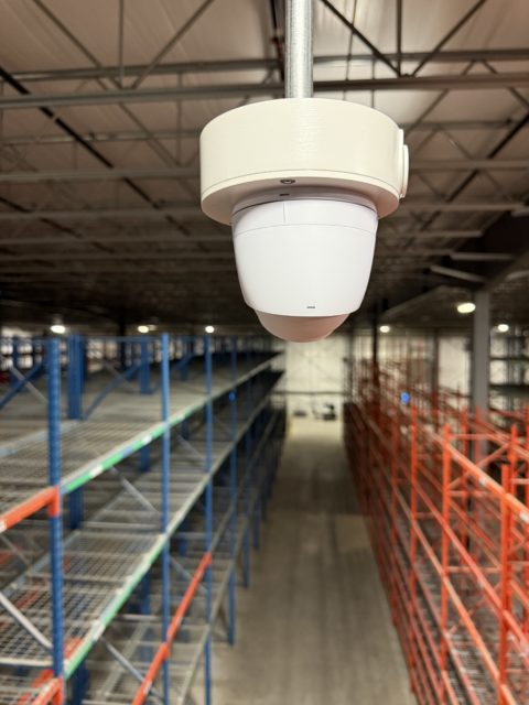 Camera mounted above warehouse shelving