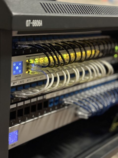 Organized network rack with labelled connections and neatly routed cabling