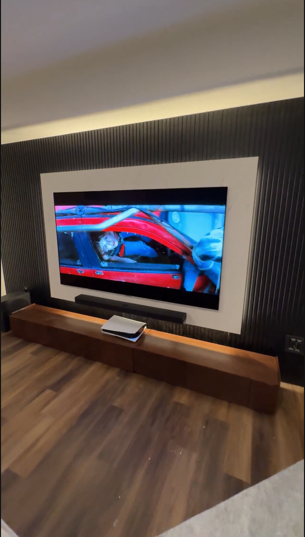 Custom TV installation with mounted TV, soundbar, PS5 and illuminated feature wall
