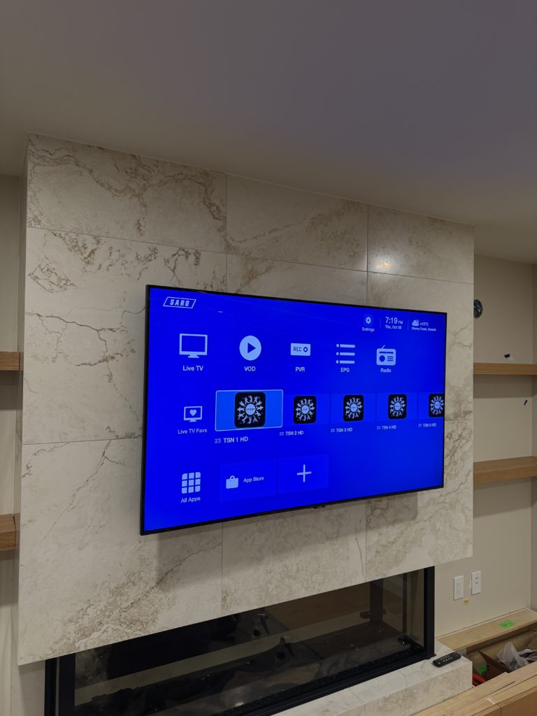 TV mounted on a light stone fireplace wall by Hamilton Tech Source